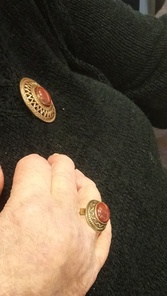 Pronssinen Uskelan sormus ja rintaneula okran värisellä kivellä